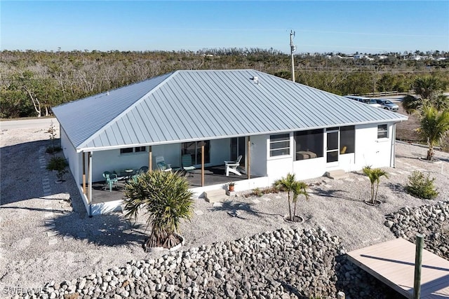 rear view of house with a sunroom and a patio