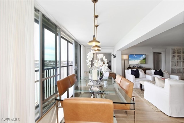 dining room with a wall of windows and hardwood / wood-style floors