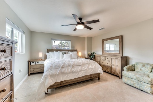 bedroom with ceiling fan, light tile patterned flooring, and multiple windows