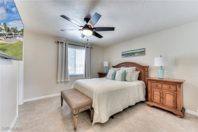 tiled bedroom featuring ceiling fan