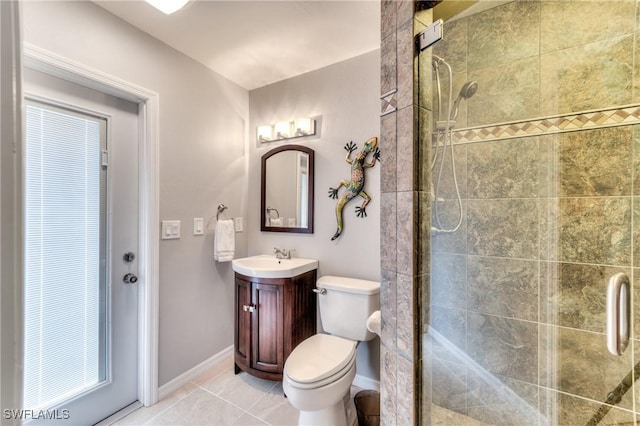 bathroom featuring tile patterned flooring, vanity, toilet, and a shower with door