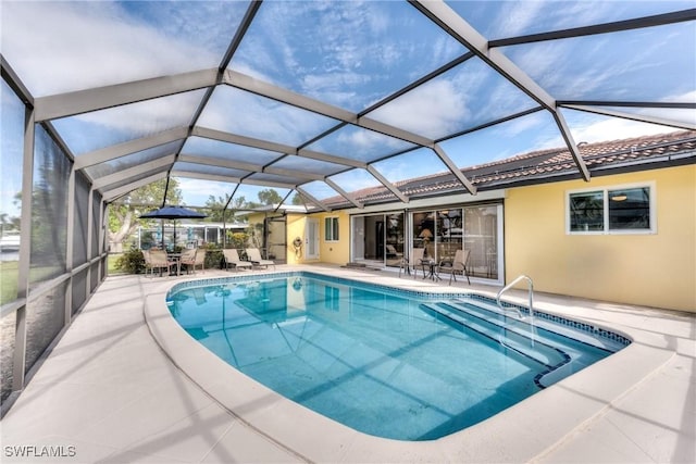 view of swimming pool with glass enclosure and a patio area