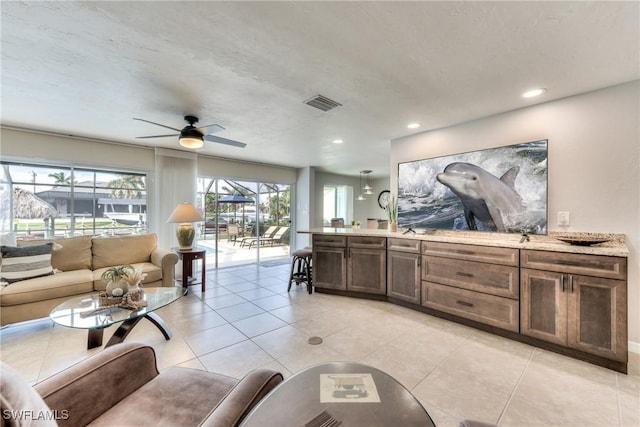 tiled living room featuring ceiling fan