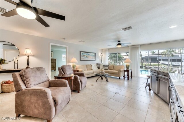 living room with ceiling fan and light tile patterned floors