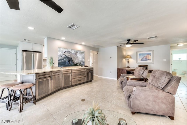 tiled living room featuring ceiling fan