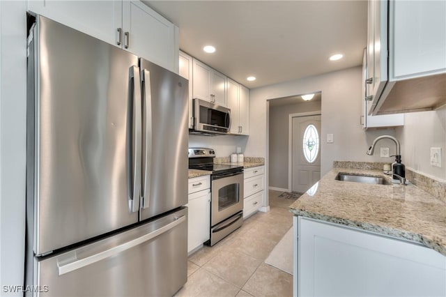 kitchen with light stone counters, sink, white cabinets, and appliances with stainless steel finishes