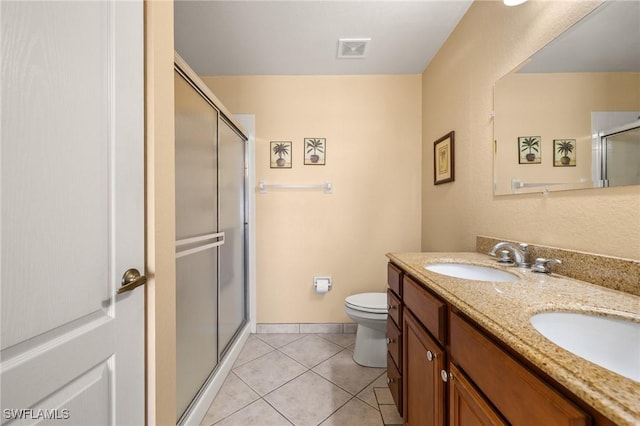 bathroom featuring vanity, toilet, tile patterned floors, and walk in shower