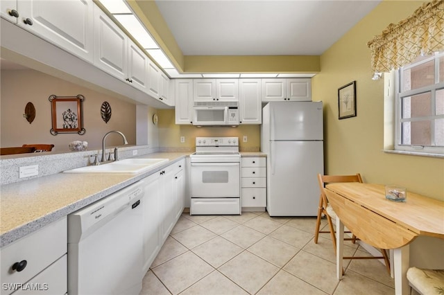 kitchen with light tile patterned floors, sink, white cabinets, and white appliances