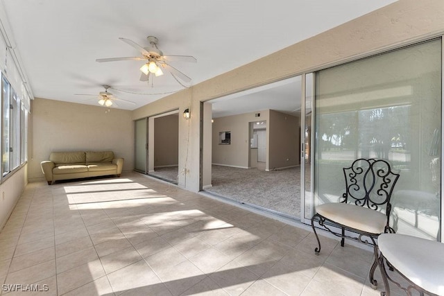 unfurnished sunroom featuring ceiling fan