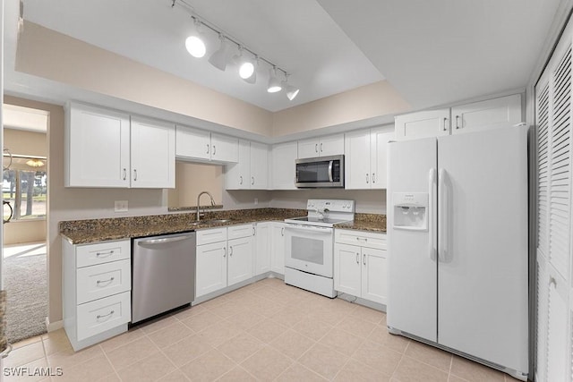 kitchen featuring sink, white cabinets, dark stone counters, and appliances with stainless steel finishes