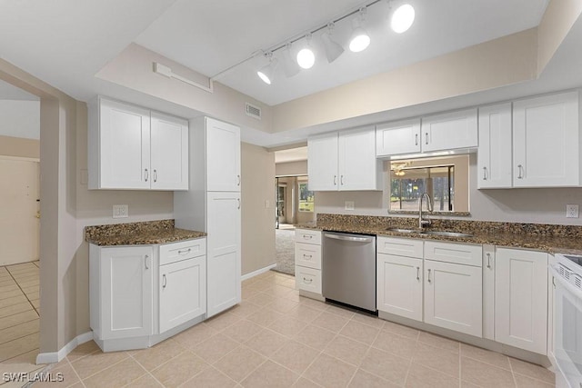 kitchen featuring dark stone counters, white cabinets, stainless steel dishwasher, and sink