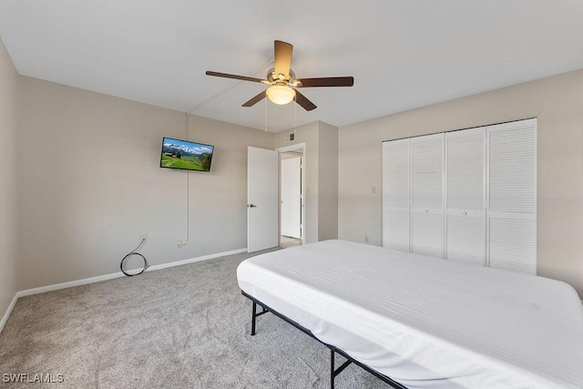 carpeted bedroom featuring ceiling fan and a closet