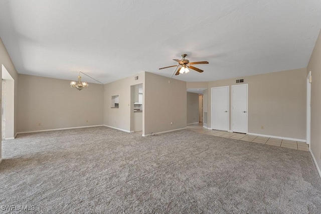 interior space featuring ceiling fan with notable chandelier and light colored carpet