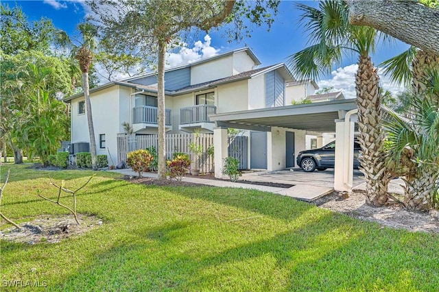 rear view of property with a yard and a carport