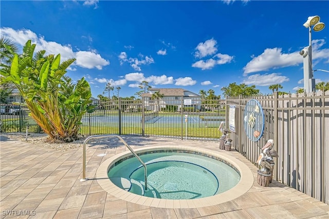 view of pool featuring an in ground hot tub and a water view