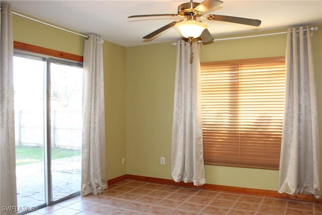 empty room with ceiling fan and light tile patterned floors