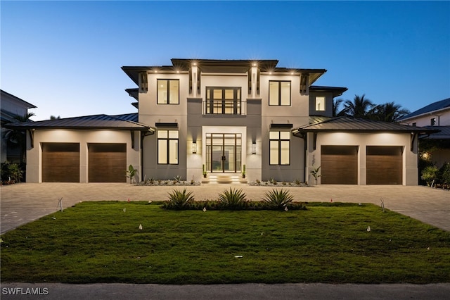 view of front of house featuring a garage, decorative driveway, a standing seam roof, and stucco siding