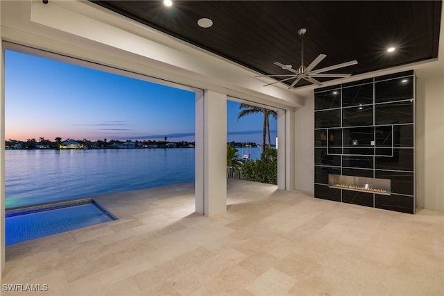 interior space with a large fireplace and a water view