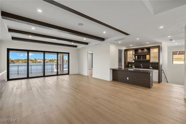 unfurnished living room featuring beamed ceiling, recessed lighting, light wood-style flooring, and baseboards