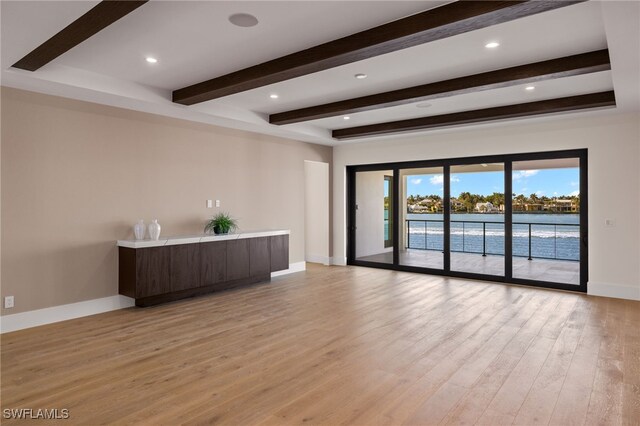 interior space featuring recessed lighting, beam ceiling, baseboards, and light wood finished floors