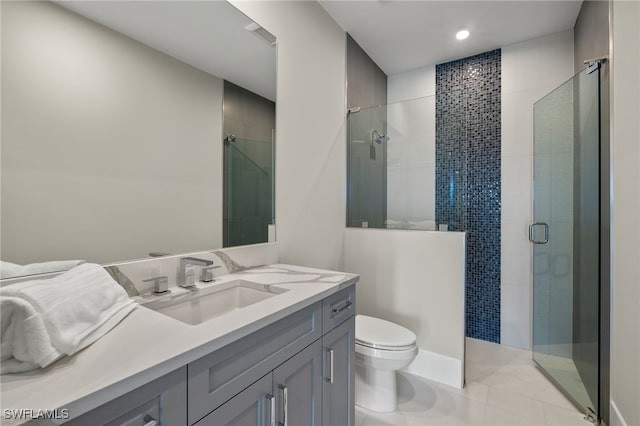 bathroom with a stall shower, vanity, toilet, and tile patterned floors