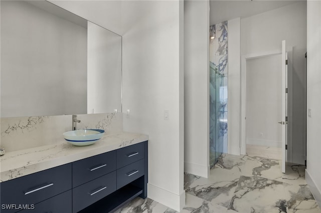 full bath with marble finish floor, a shower, vanity, and baseboards