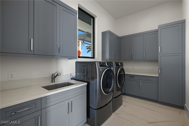 washroom featuring washing machine and dryer, a sink, and cabinet space