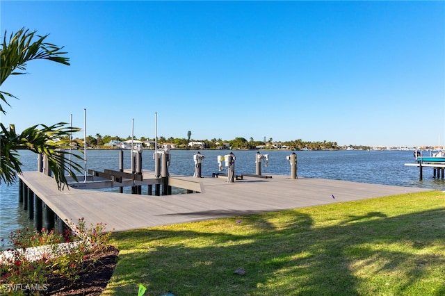 view of dock featuring a water view and a yard