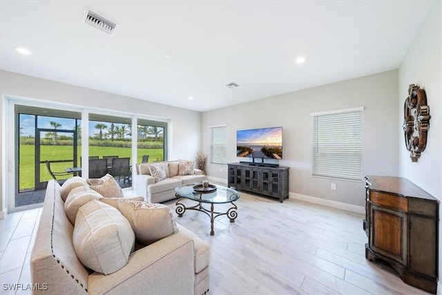 living room with recessed lighting, visible vents, and baseboards