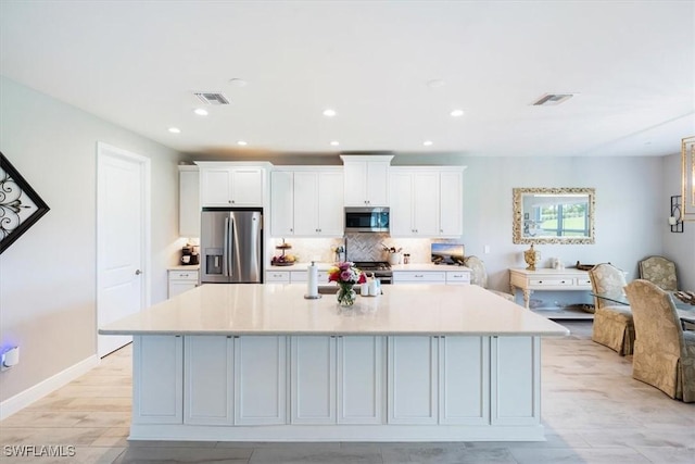 kitchen with white cabinets, a large island, and appliances with stainless steel finishes