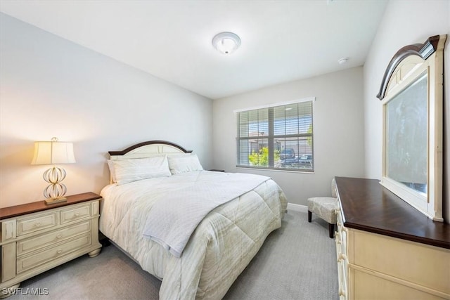 bedroom featuring light carpet and baseboards