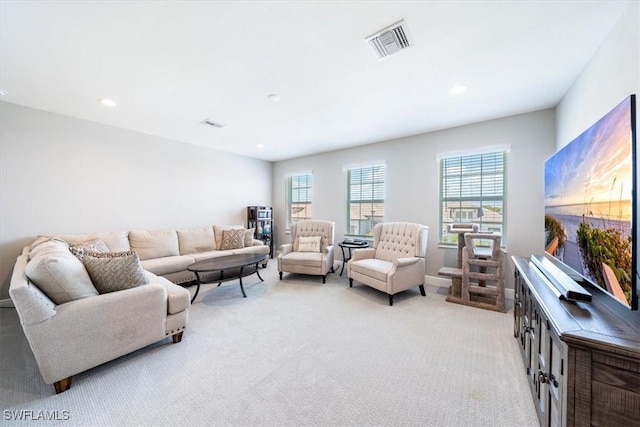 living room featuring light colored carpet, visible vents, baseboards, and recessed lighting