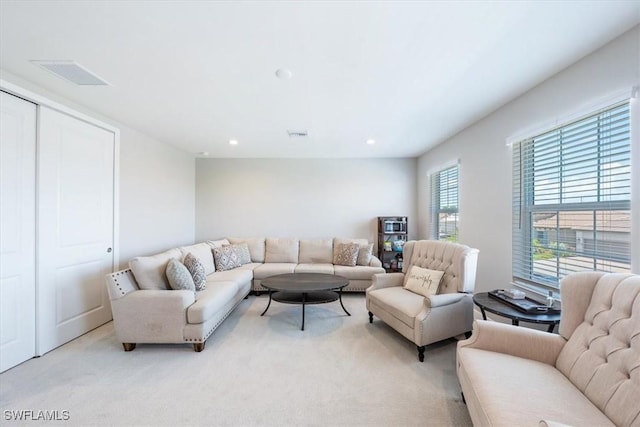 living room featuring recessed lighting, visible vents, and light colored carpet