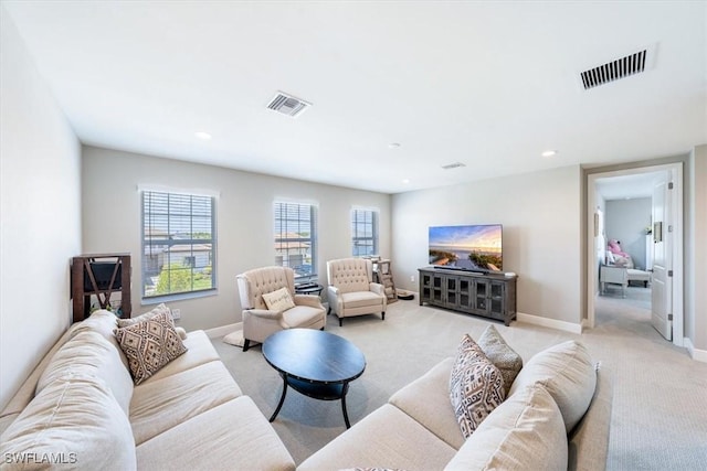 living area featuring recessed lighting, baseboards, visible vents, and light colored carpet