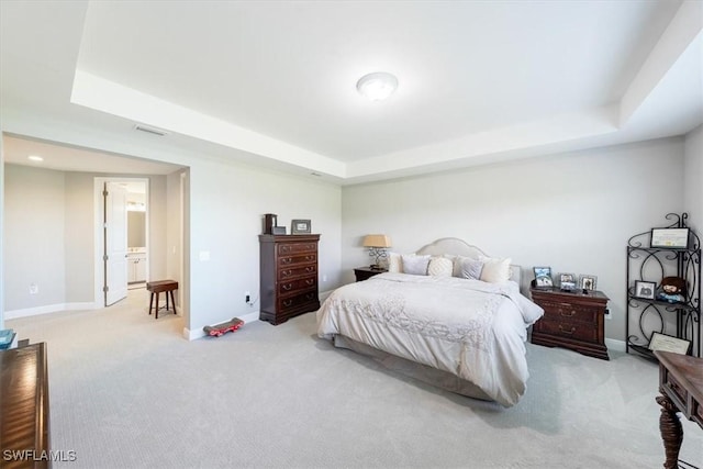 bedroom with light carpet, a tray ceiling, visible vents, and baseboards