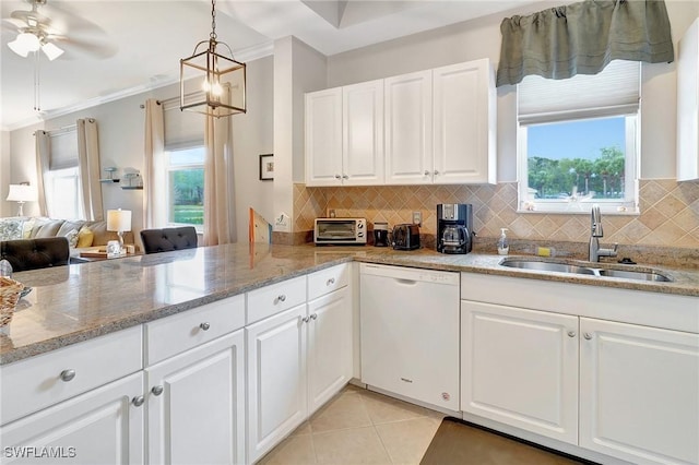 kitchen featuring white dishwasher, light stone countertops, white cabinetry, and sink