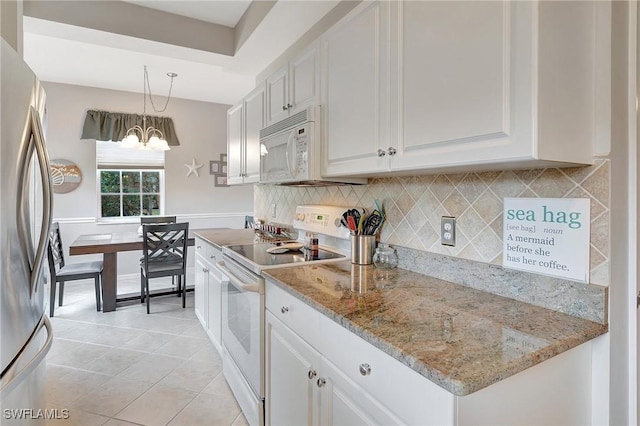 kitchen featuring white cabinets, white appliances, an inviting chandelier, and hanging light fixtures