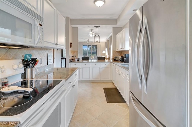 kitchen featuring stainless steel fridge, electric range, white cabinetry, and backsplash