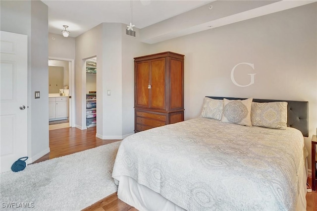 bedroom featuring light wood-type flooring and connected bathroom