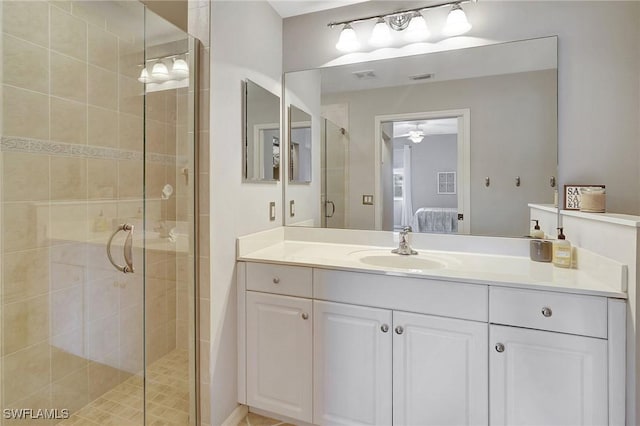 bathroom with ceiling fan, a shower with door, and vanity