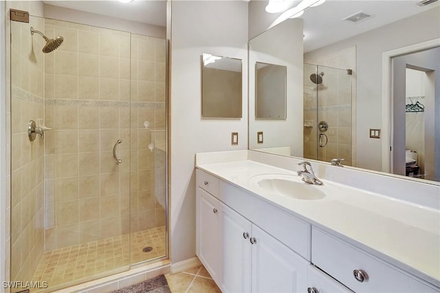 bathroom with tile patterned flooring, vanity, and a shower with door