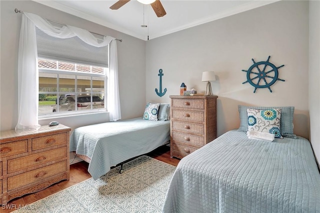 bedroom featuring light hardwood / wood-style flooring, ceiling fan, and ornamental molding