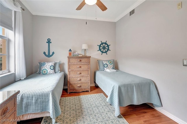 bedroom featuring ceiling fan, crown molding, and light hardwood / wood-style floors