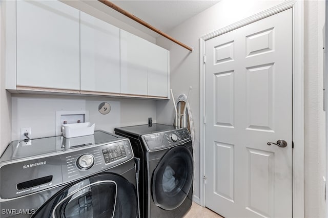 washroom with cabinets and washer and clothes dryer