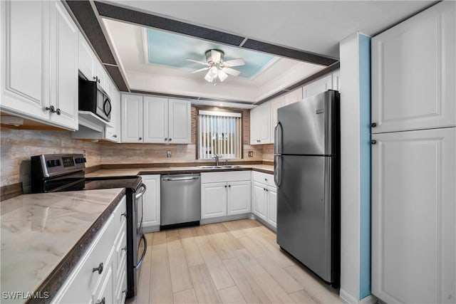 kitchen featuring white cabinetry, sink, ceiling fan, stainless steel appliances, and tasteful backsplash