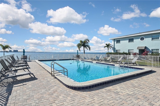 view of pool featuring a patio and a water view