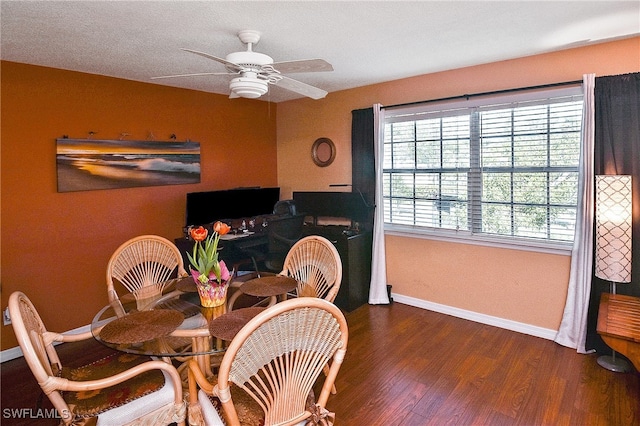 dining area with a textured ceiling, ceiling fan, and dark wood-type flooring