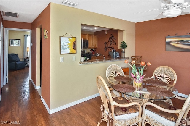 dining room with ceiling fan and dark hardwood / wood-style flooring