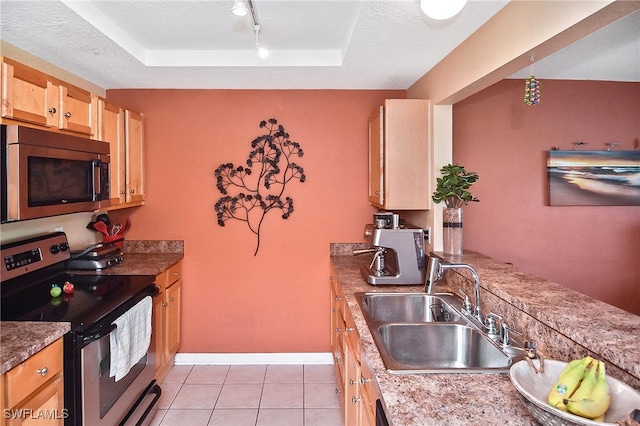 kitchen with a textured ceiling, stainless steel appliances, light tile patterned floors, rail lighting, and sink