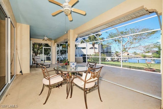 sunroom with a water view and ceiling fan